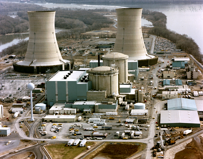 Three Mile Island nuclear generating station viewed across the Susquehanna River, showing four cooling towers and two reactor containment domes.