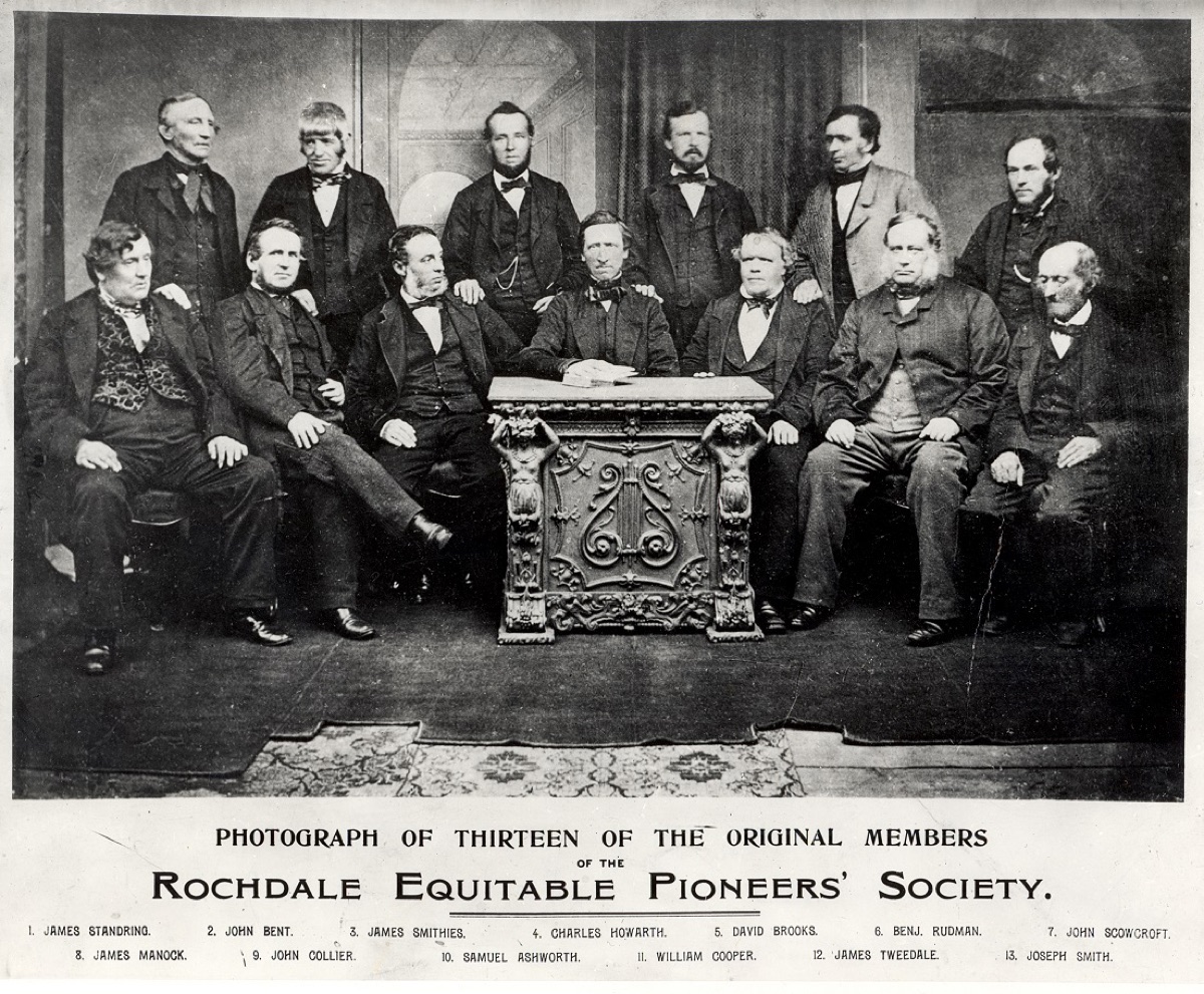 A posed 1865 group portrait of thirteen Victorian men, the surviving founders of the Rochdale Society of Equitable Pioneers.